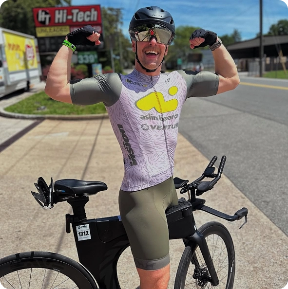 Triathlete posing with a bike at a race